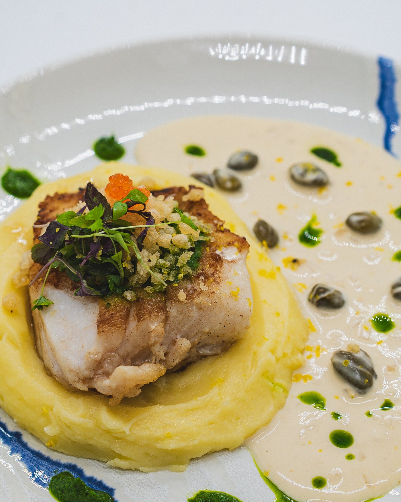 Pan-fried cod loin with white wine and caper sauce on crushed potato